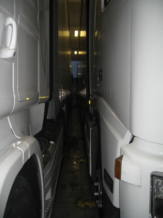 Narrow gap between two white trucks