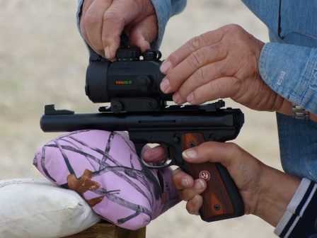 Close-up of hands holding 22 black target pistol with a large sight